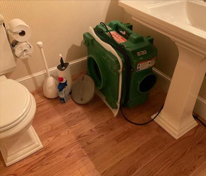 HEPA filter air scrubber positioned in the corner of a bathroom