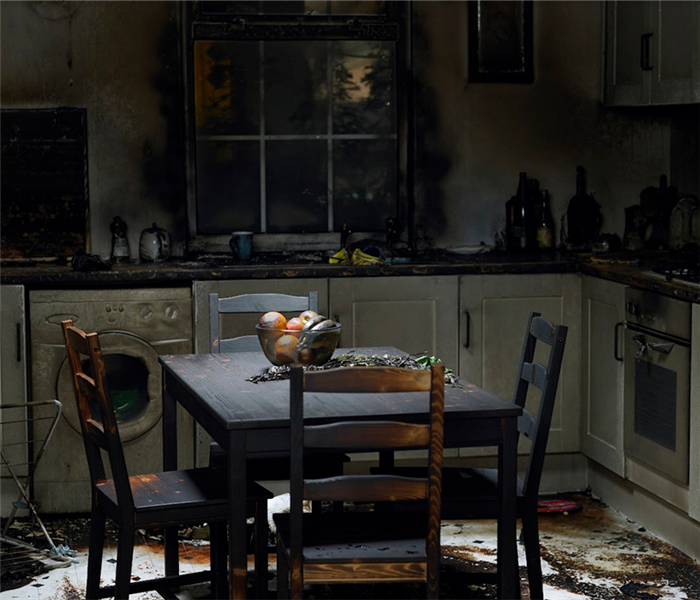 a fire damaged kitchen with soot covering the table and counters